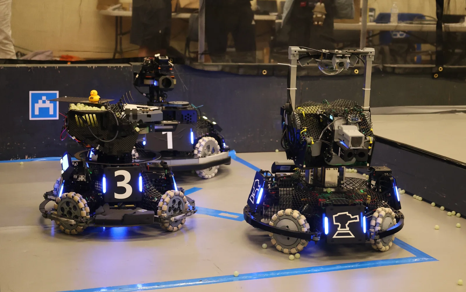 Three RoboGrinder competition robots on the arena floor